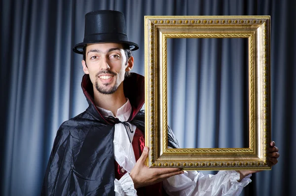Magician with photoframe in studio — Stock Photo, Image