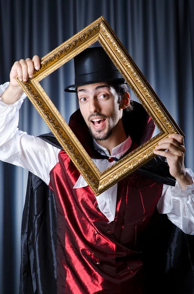 Magician with photoframe in studio — Stock Photo, Image