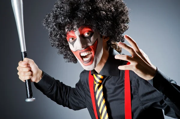 Grappige clown met bat in studio — Stockfoto