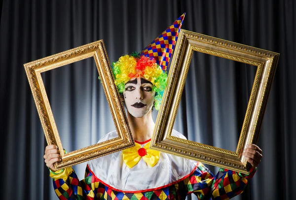 Clown met afbeeldingsframes in studio — Stockfoto