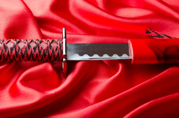 Japonês takana espada no fundo de cetim vermelho — Fotografia de Stock