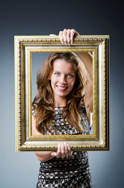 Ung kvinna med fotoram på vit — Stockfoto
