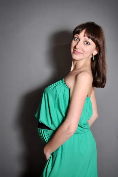 Молода красива вагітна жінка в зеленому — стокове фото