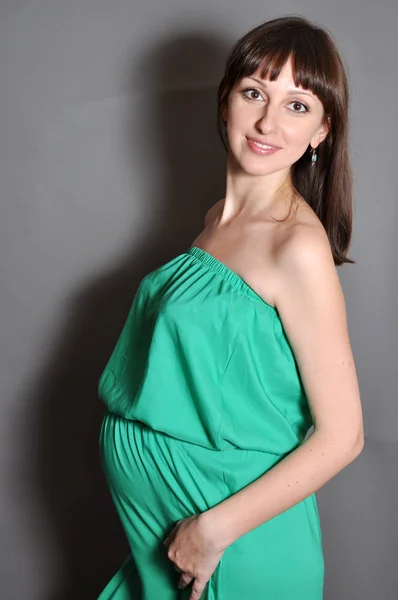 Молодая красивая беременная женщина в зеленом — стоковое фото