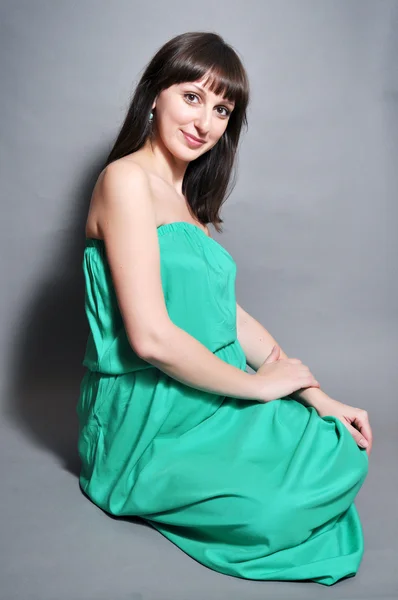 Молодая красивая беременная женщина в зеленом — стоковое фото