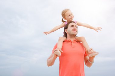 Father carrying his daughter on shoulders clipart