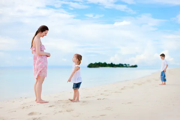 Mor och två barn på stranden — Stockfoto