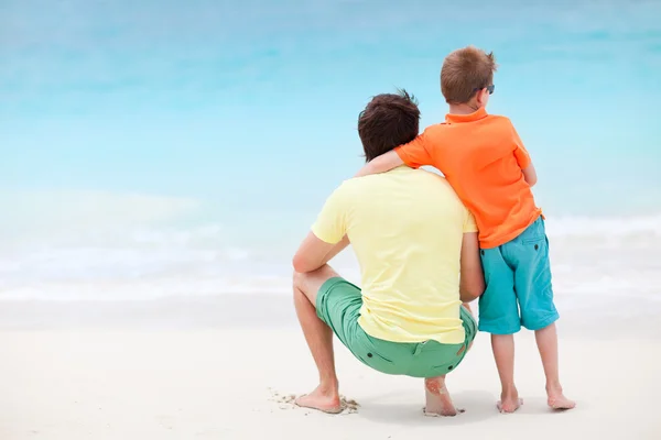 Far och son på stranden — Stockfoto