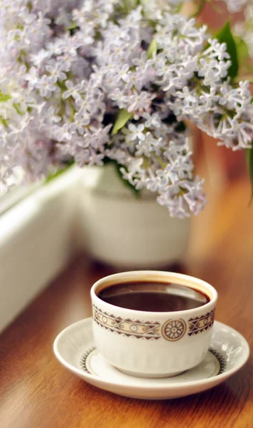Ceramic cup with coffee and bouquet of lilac — Stock Photo, Image