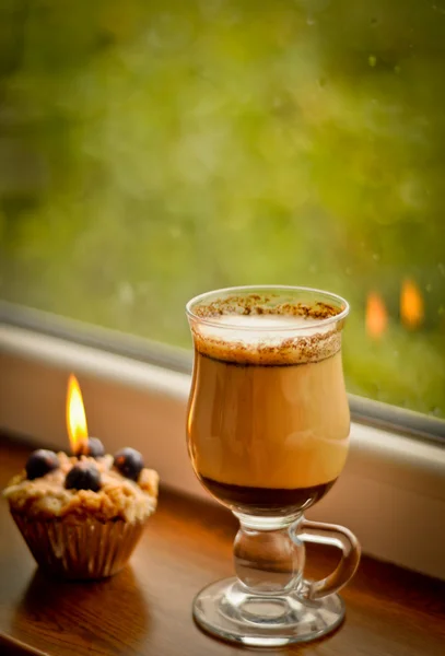 ? offee latte och ett tänt ljus på regnigt fönster — Stockfoto