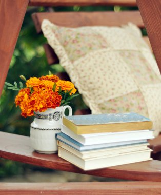 Books, and marigolds in a vase stock image clipart