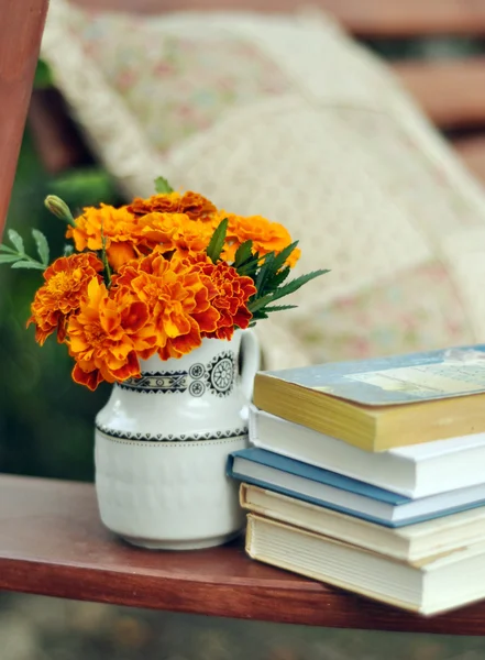 Książki i nagietki w obraz pień wazon — Zdjęcie stockowe