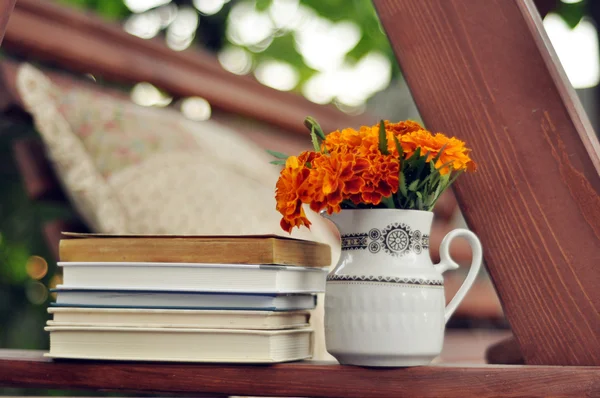 Books, and marigolds in a vase stock image — Stock Photo, Image