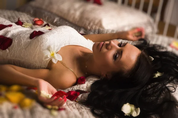 Sexuální brunetka ležící na posteli — Stock fotografie