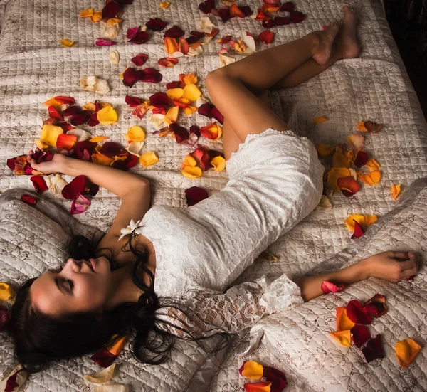 Sexuální bruneta spaní na posteli — Stock fotografie