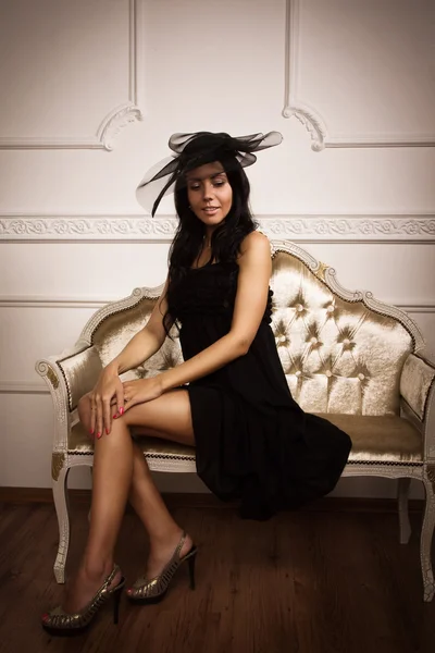 Atrakcyjny brunetka siedzi na kanapie — Zdjęcie stockowe