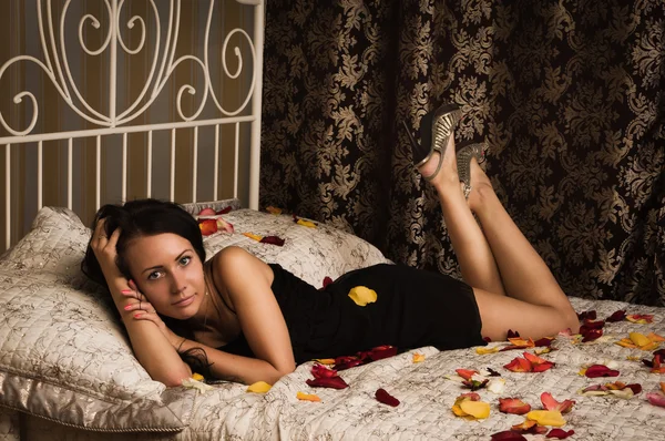 Aantrekkelijke brunette liggend op het bed — Stockfoto