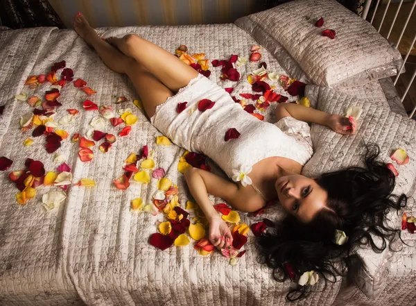 Sexuella brunett liggande på en säng — Stockfoto