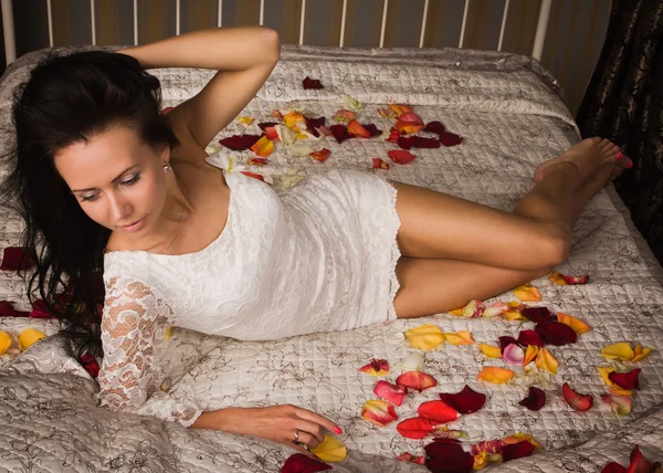 Привлекательная брюнетка лежит на кровати — стоковое фото