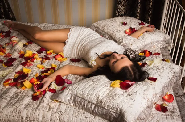 Morena sexual dormindo em uma cama — Fotografia de Stock