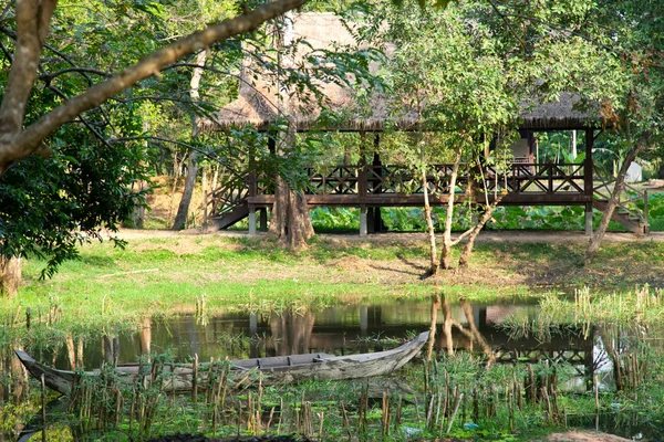 Träbåt på sjön i asiatisk skog — Stockfoto