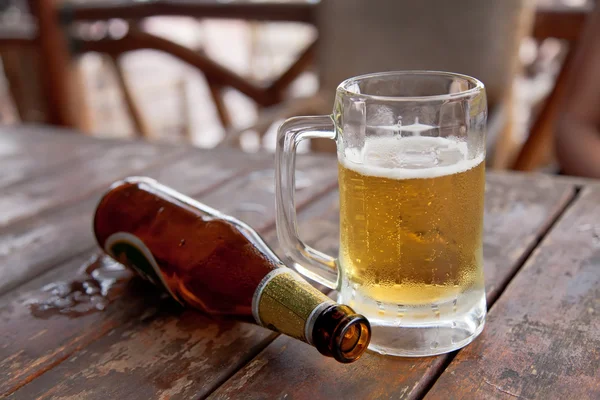 Garrafa vazia e o copo de cerveja — Fotografia de Stock