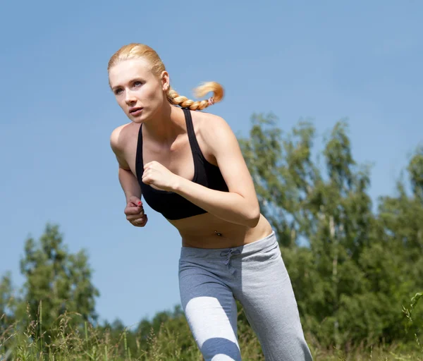 Beautiful young woman runner in nature — Stock Photo, Image