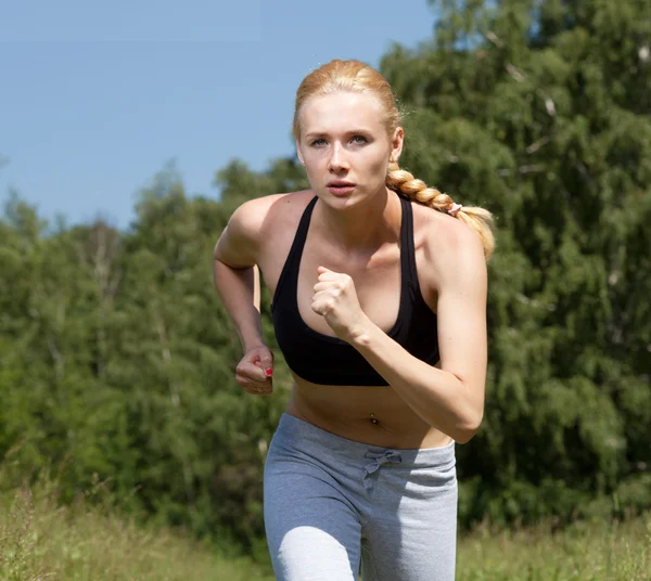 Beautiful young woman runner in nature — Stock Photo, Image