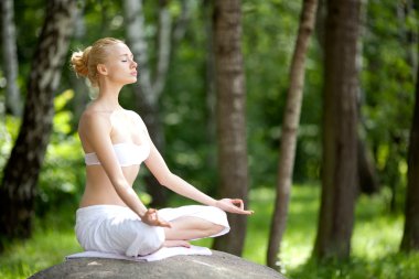 Young girl doing yoga in the park clipart