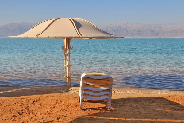 Beach umbrella and deck chair waiting for tourists — Stock Photo, Image