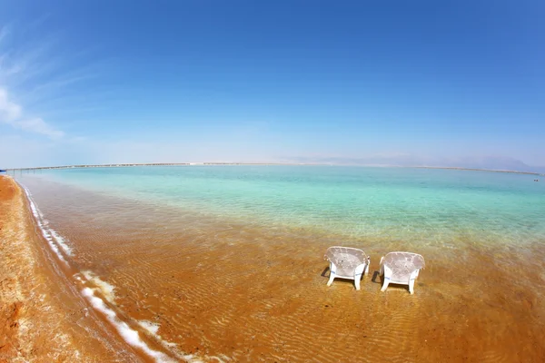 Duas cadeiras de praia brancas estavam na água — Fotografia de Stock