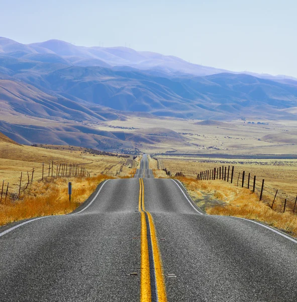 La pradera californiana y las montañas, la carretera y las vallas — Foto de Stock