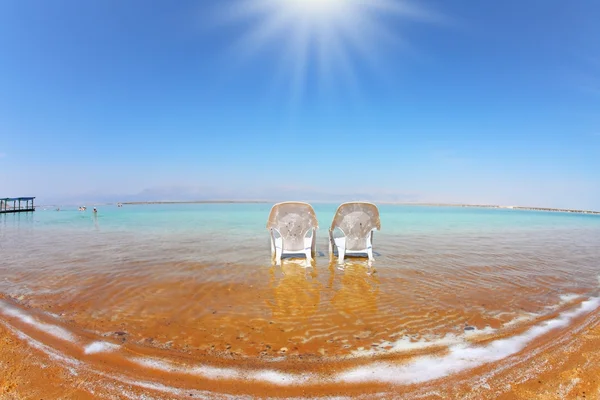 Duas poltronas de praia brancas na água — Fotografia de Stock