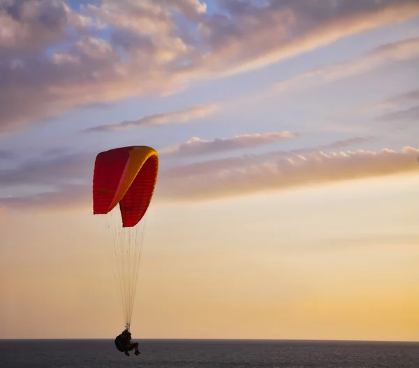 O paraquedas operado voa baixo acima do mar — Fotografia de Stock