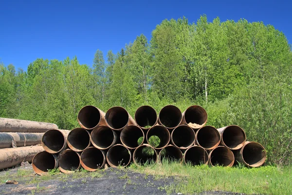 Old gas pipes amongst green herb — Stock Photo, Image