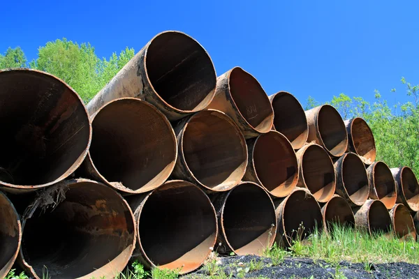 Antigos tubos de gás entre ervas verdes — Fotografia de Stock