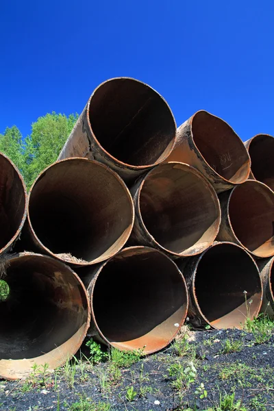 Antigos tubos de gás entre ervas verdes — Fotografia de Stock