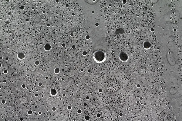 Pluie goutte à goutte sur le cellophane gris — Photo