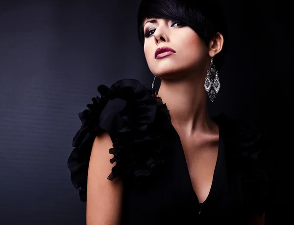 Bella donna su abito classico nero posa in studio. — Foto Stock