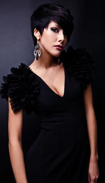 Mooie vrouw op zwart klassiek jurk pose in studio. — Stockfoto