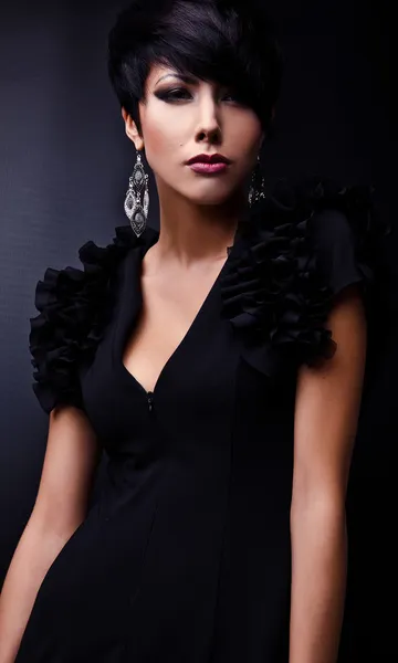 Schöne Frau im schwarzen klassischen Kleid posiert im Studio. — Stockfoto