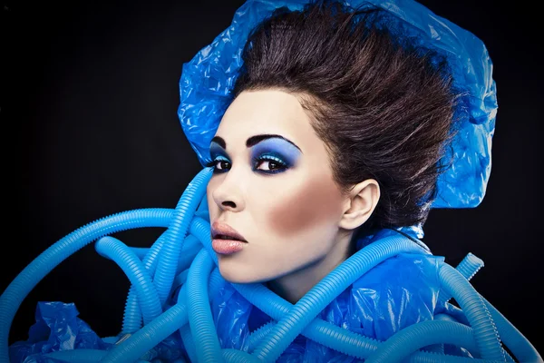 Futuristische mooie jonge vrouwelijke gezicht met blauwe fashion make-up. — Stockfoto