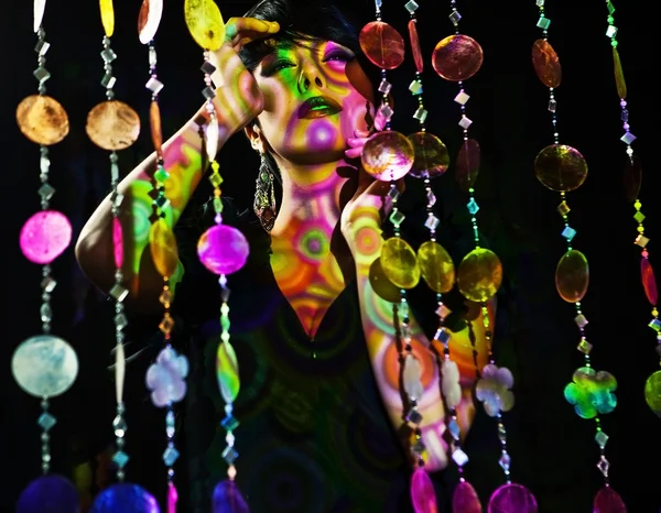 Mooi meisje vormen op kleurrijke licht — Stockfoto