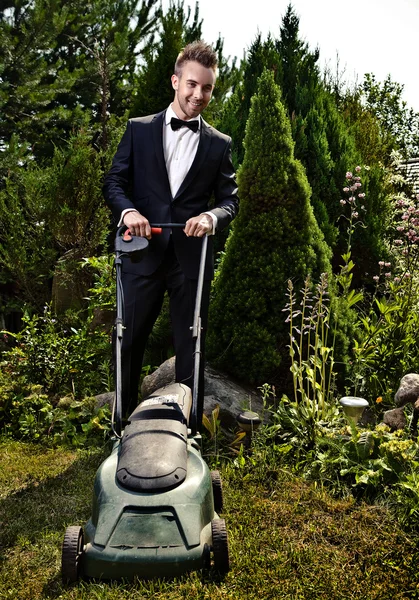 グラマー庭師は芝生芝刈り機で草を刈ってください。 — ストック写真