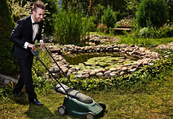 Glamour jardinero corta una hierba con cortacésped — Foto de Stock
