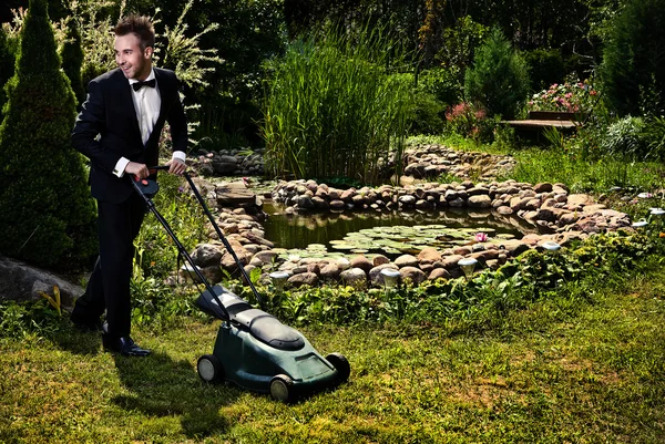 Glamour bahçıvan bir çim çim biçme makinesi ile mows — Stok fotoğraf