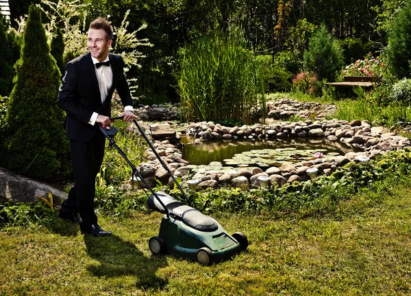 Glamour gardener mows a grass with lawn-mower — Stock Photo, Image
