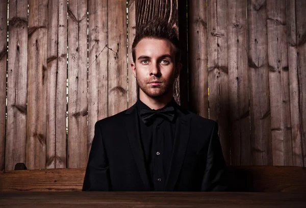 Portrait of young beautiful fashionable man against wood wall. — Stok Foto