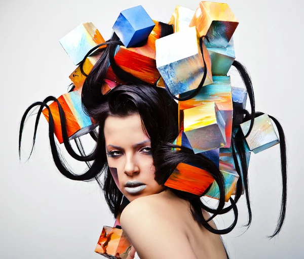 Mode close-up portret van mooie jonge meisje met kubussen op hoofd. conceptuele foto. — Stockfoto