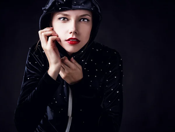 Poseren vrouw in trendy kostuum op donkere achtergrond. — Stockfoto